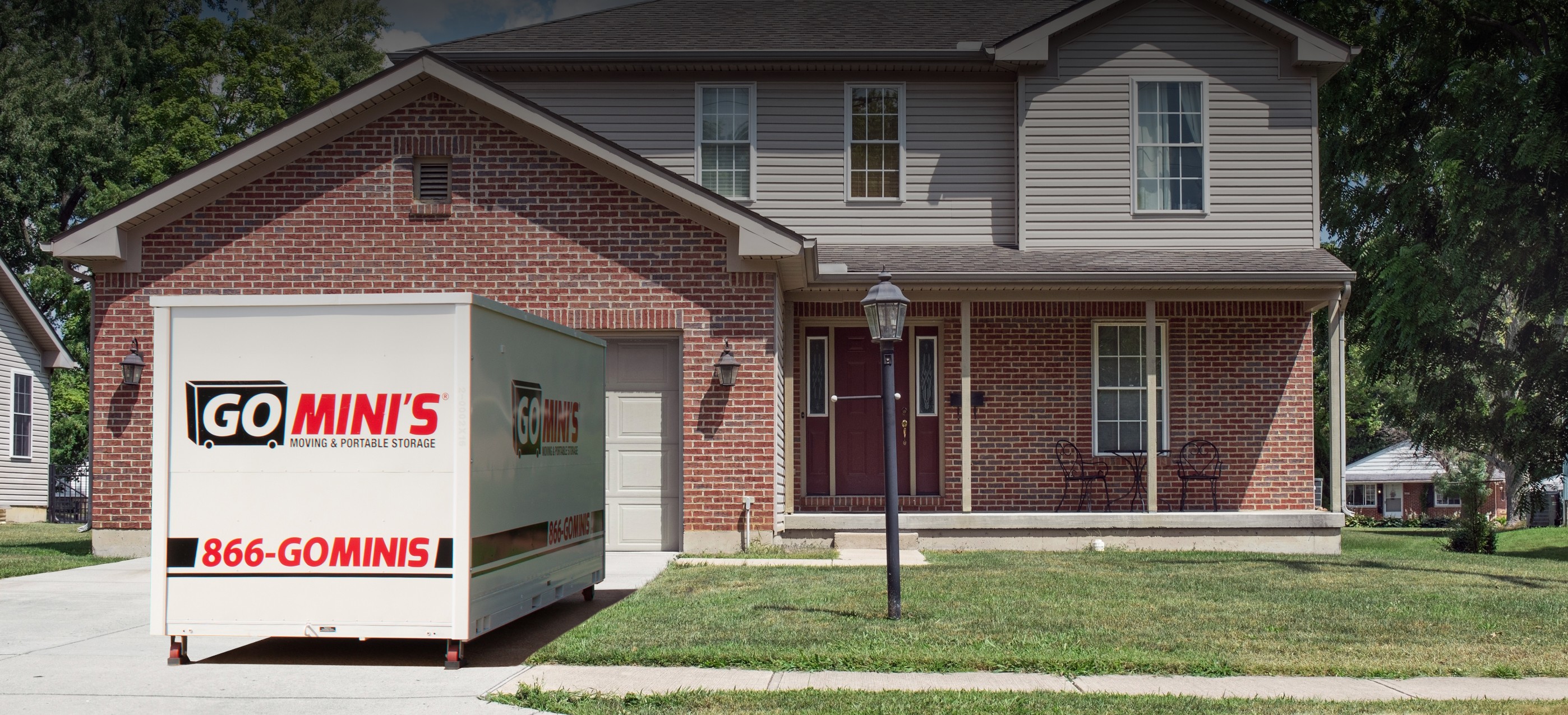 brick house with go minis container in driveway